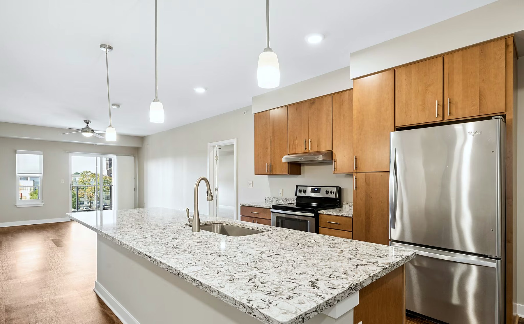 A kitchen at Charlotte Square, with a stone-topped island, stainless appliances and pendant lighting