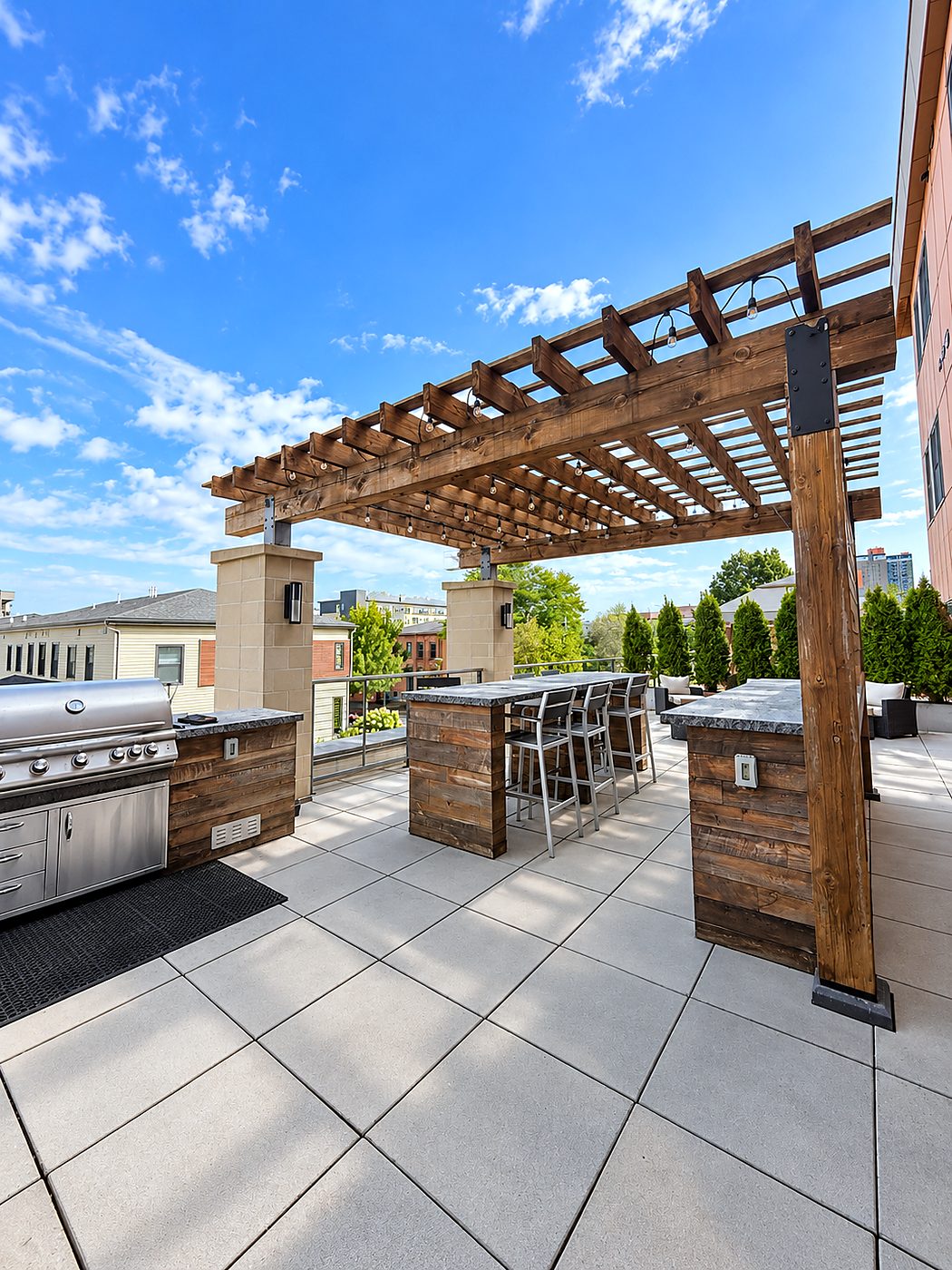The shared terrace at Charlotte Square, with the pergola, the grills and the Rochester skyline beyond